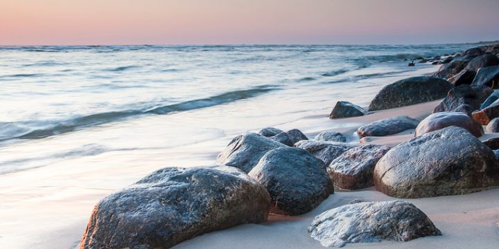 Strand mit Steinen im Sand