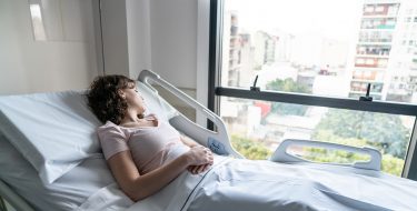 Junge Frau liegt im Krankenbett